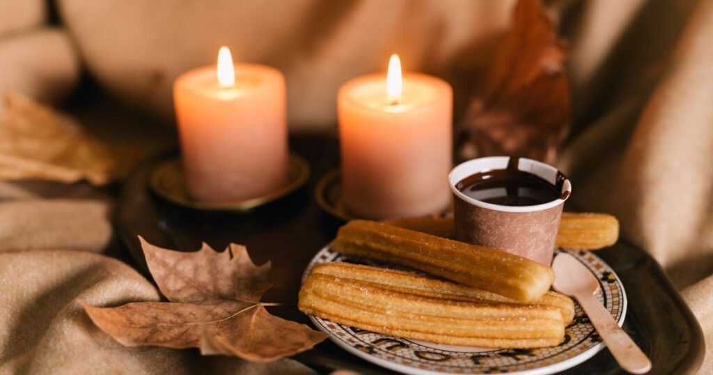Churros con chocolate junto a dos velas