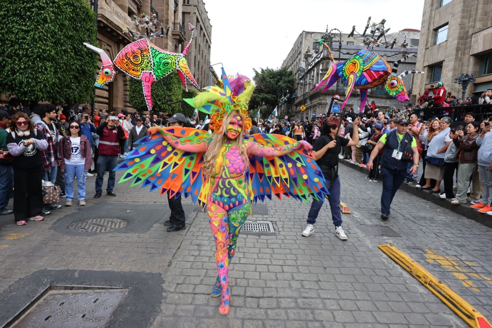 Artista con maquillaje y alas multicolores en el desfile de alebrijes monumentales 2026 en CDMX