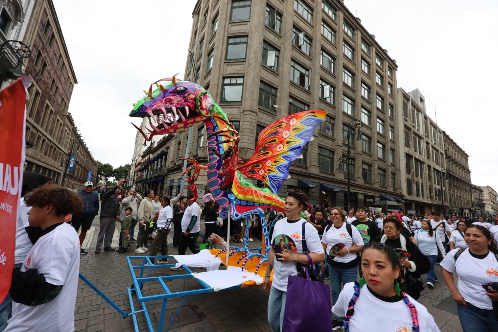 Alebrije monumental de dragón con alas de colores desfilando en CDMX