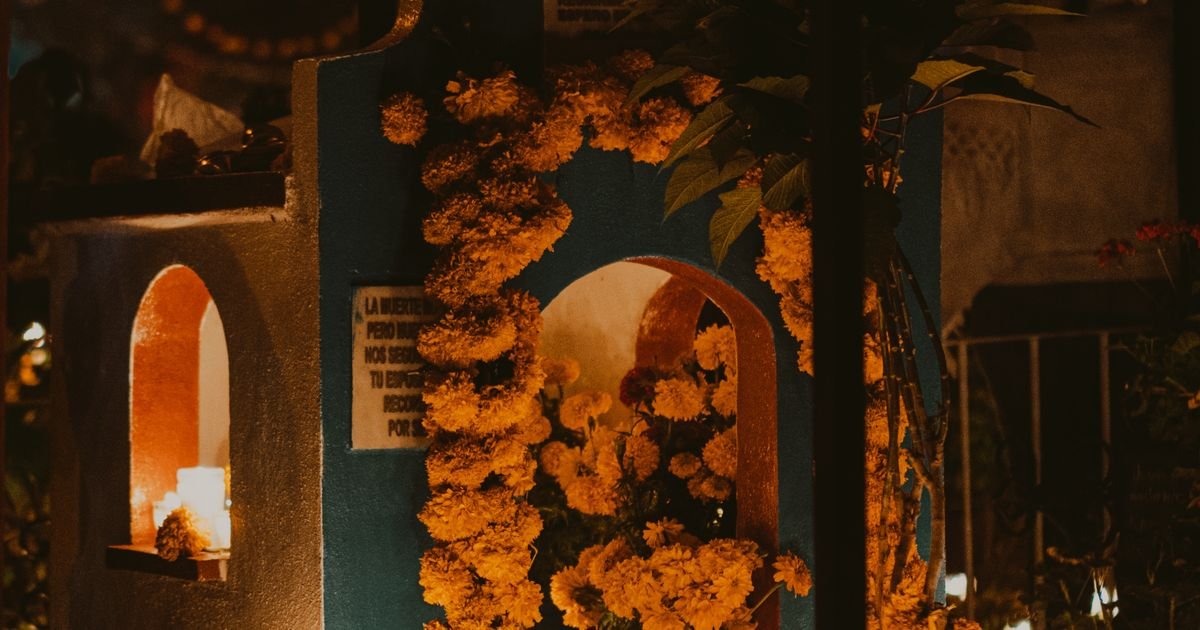 Altar de Día de Muertos iluminado y decorado con flores