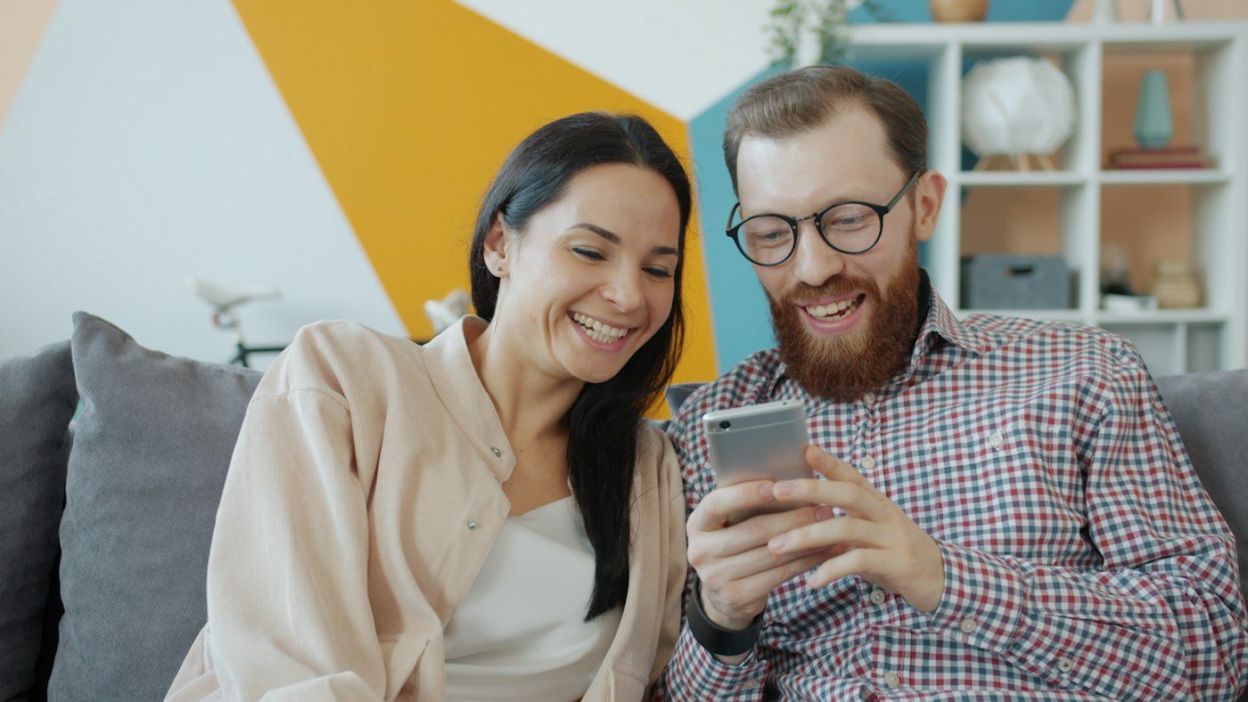 Personas utilizando smartphone en casa, imagen ilustrativa