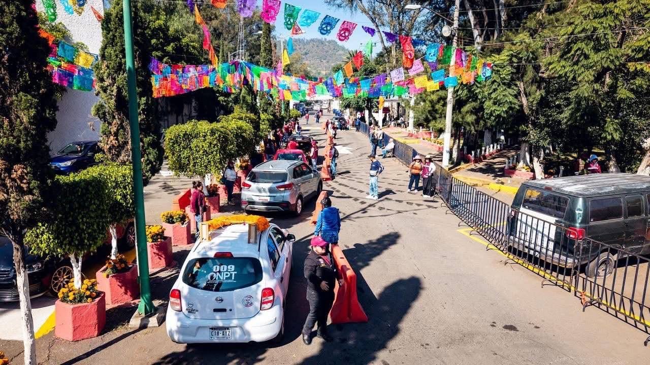 Visitantes y flores en un panteón de Iztapalapa durante la conmemoración de Día de Muertos